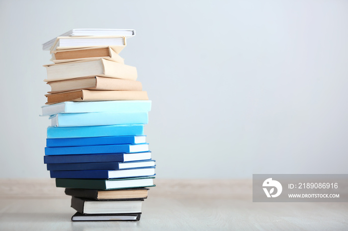 Stack of different books on light background