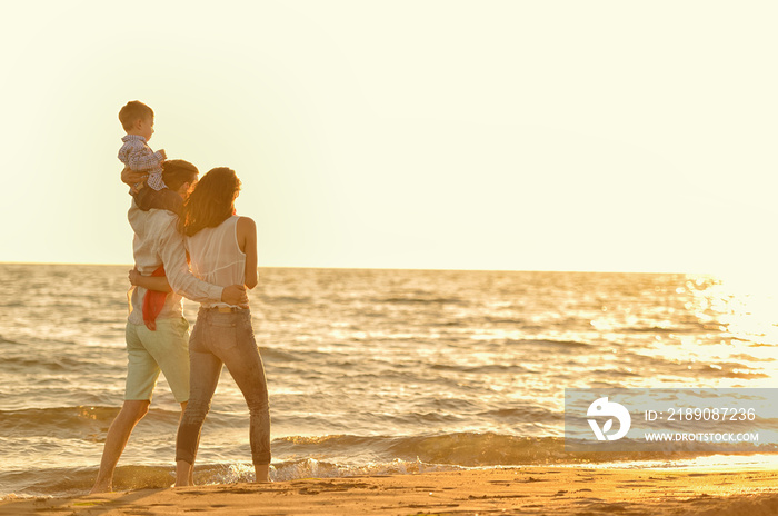 happy young family have fun on beach run and jump at sunset