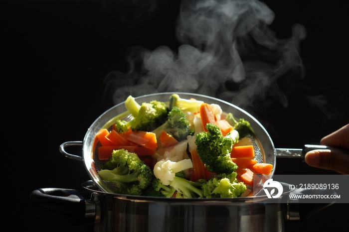 热煮蔬菜的蒸制。刚用蒸汽从热水中煮出来的一篮子蔬菜