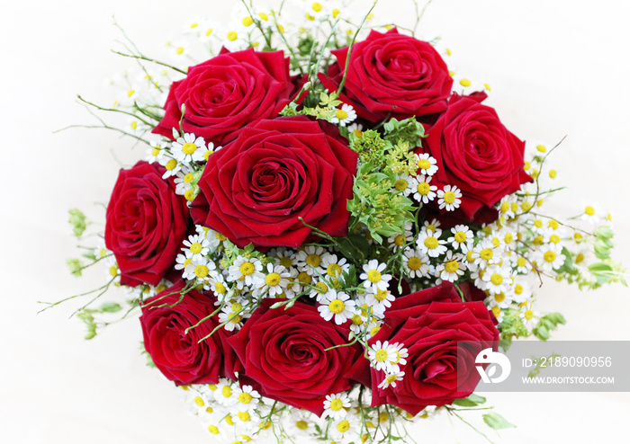 Romantic and colorful flower wedding bouquet with red roses and romantic white chamomile flowers 