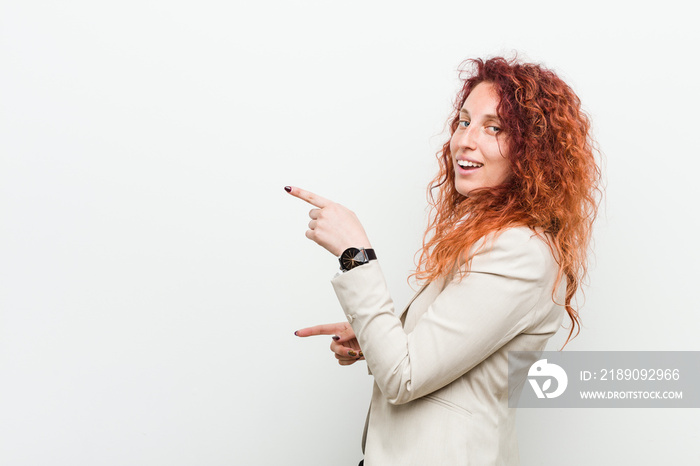 Young natural redhead business woman isolated against white background excited pointing with forefin