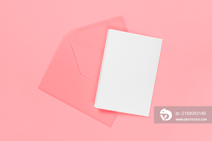 空白白色卡片，蓝色背景上有粉红色信封。模板或实物模型。带co的横幅