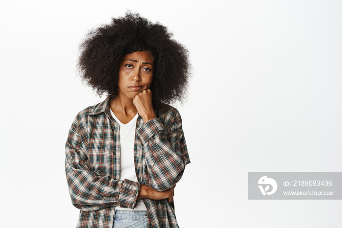 Bored and sad african american woman looking with unamused, gloomy face expression, standing indiffe