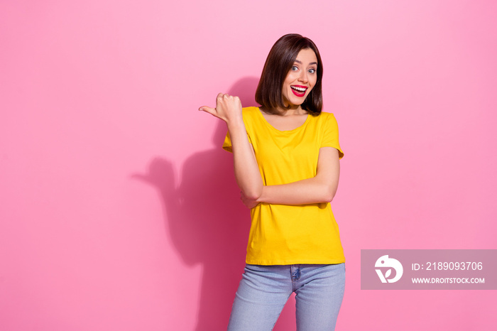 Portrait of attractive funky cheerful girl demonstrating copy space isolated over pink pastel color 