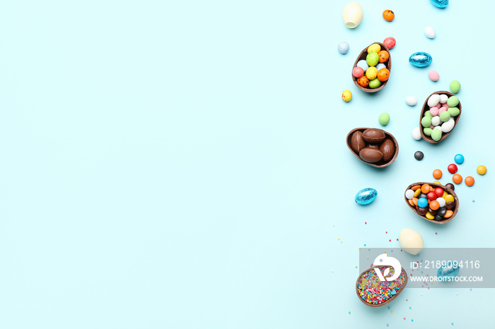 Composition with chocolate Easter eggs, candies and sprinkles on blue background
