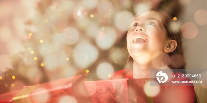 Composite image of little girl opening a magical christmas gift