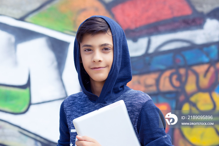 Happy smiling young man, boy looking at you camera holding tablet pad present touch screen