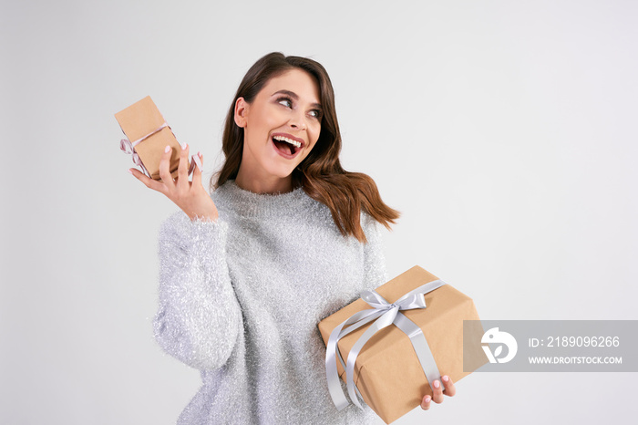 Happy woman holding two gifts in studio shot