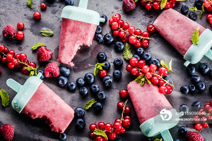 top view of delicious sweet ice lollies and fresh ripe berries on grey surface