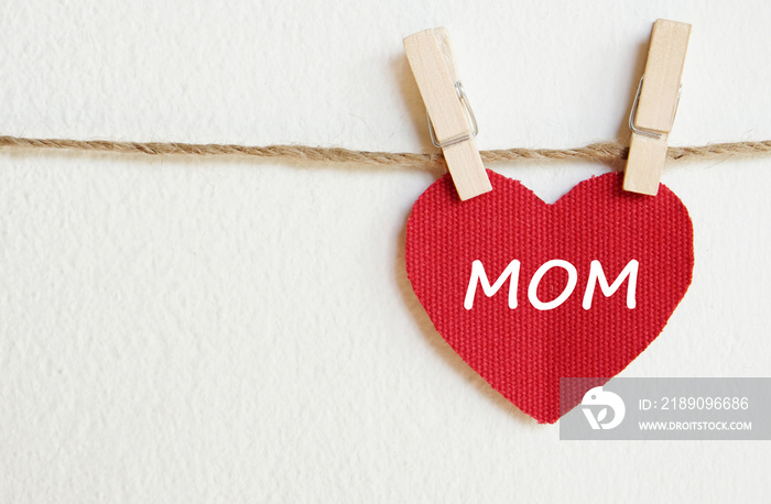 母亲节快乐贺卡，红色织物上的爱妈妈字，心形挂在白色的后背上