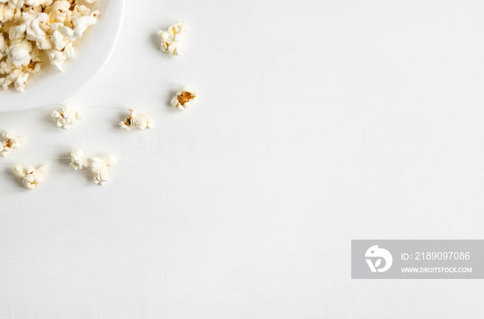 Background with a plate of popcorn. White background with popcorn. Place for inscription