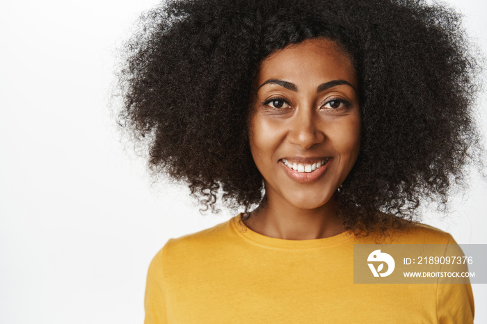 微笑的现代非裔美国女性的肖像，穿着黄色t恤，看起来很自信