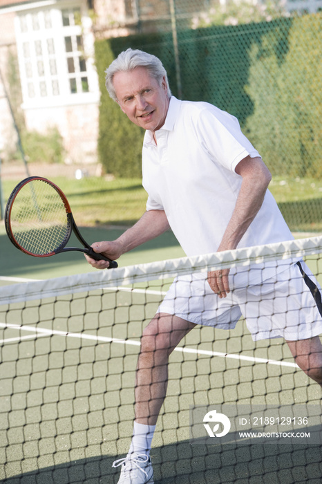 Man playing tennis and smiling