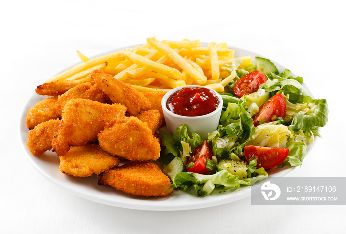 Fried chicken nuggets, French fries and vegetables