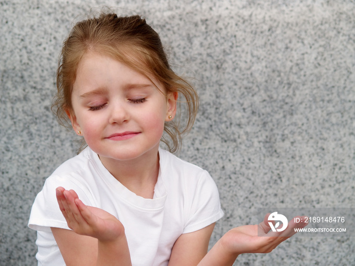 小女孩双手翘起，像是在祈祷或冥想