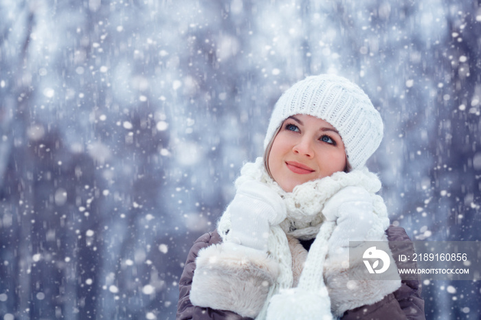 美丽的女人在雪下走在户外