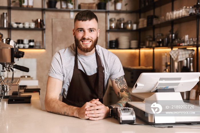 Smiling attractive man barista standing