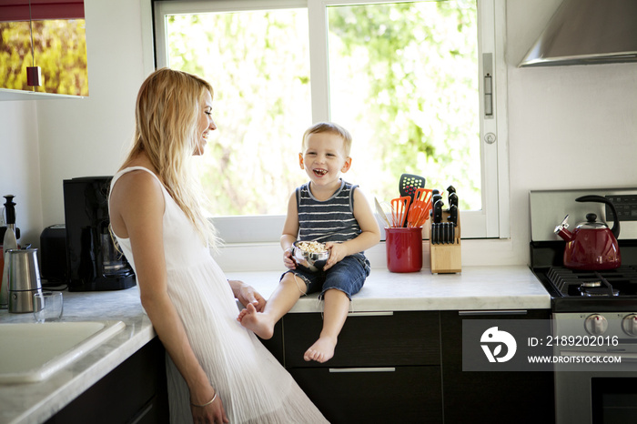 Mother and son laughing in kitchen