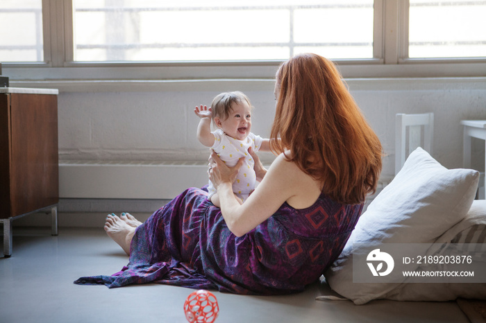 Mother laughing with baby girl (6-11 months)