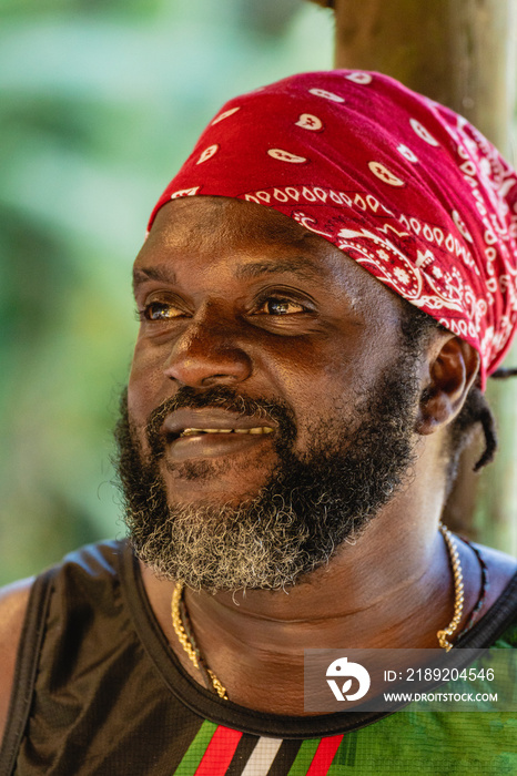 Retrato vertical de un hombre afro caribeño con un pañuelo en su cabeza, el hombre sonriente de barb