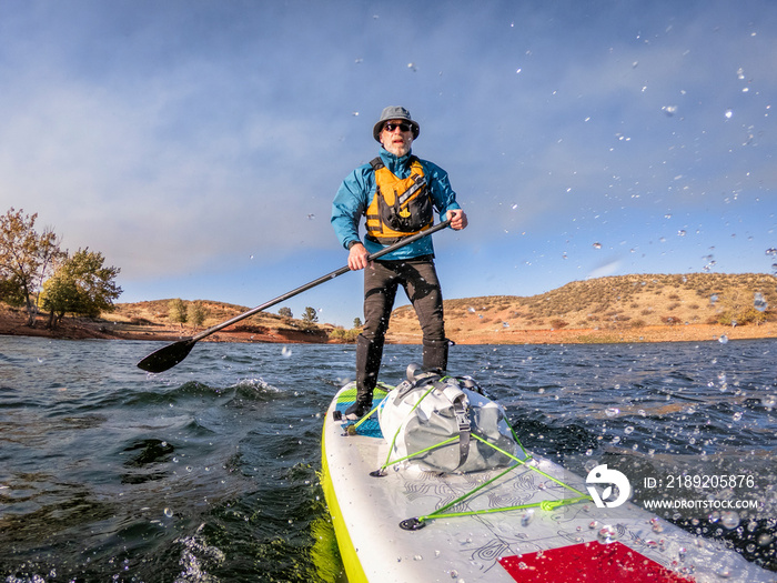 senior man paddling a stand up paddleboard