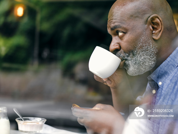 UK,ÊProfileÊof man drinking coffee at breakfast table