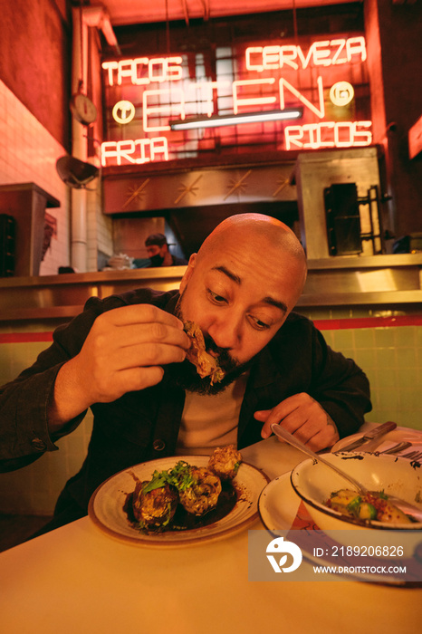 Man eating food in Mexican restaurant