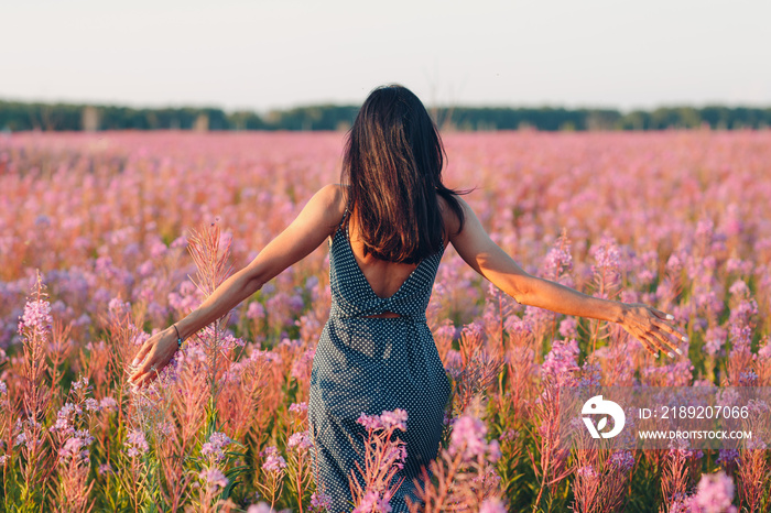 Girl on blooming Sally flower field. Lilac flowers and woman