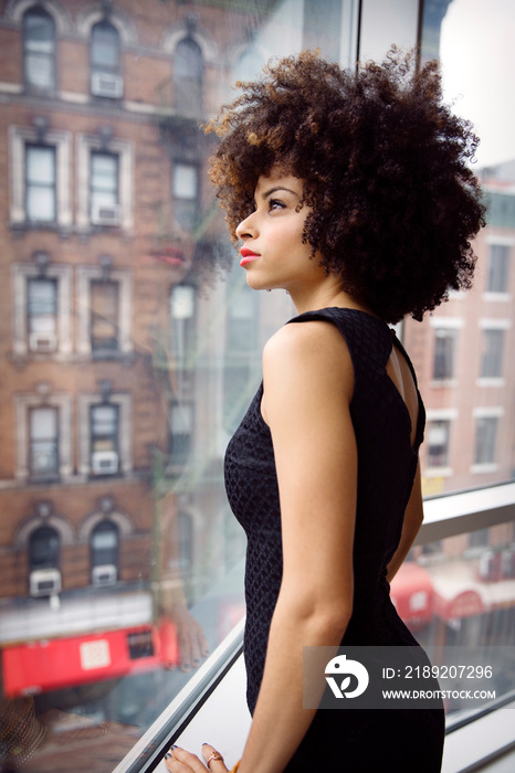 Young woman looking through window