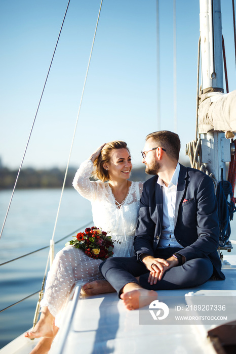 Beautiful wedding couple on yacht at wedding day outdoors in the sea. Beautiful elegant  bride in a 