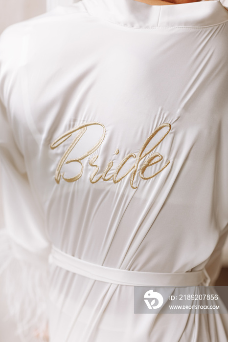 Morning of bride. Gorgeous bride. beautiful woman in a white robe with the inscription bride. the mo