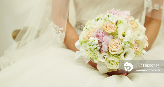Bride in wedding dress holding flower bouquet