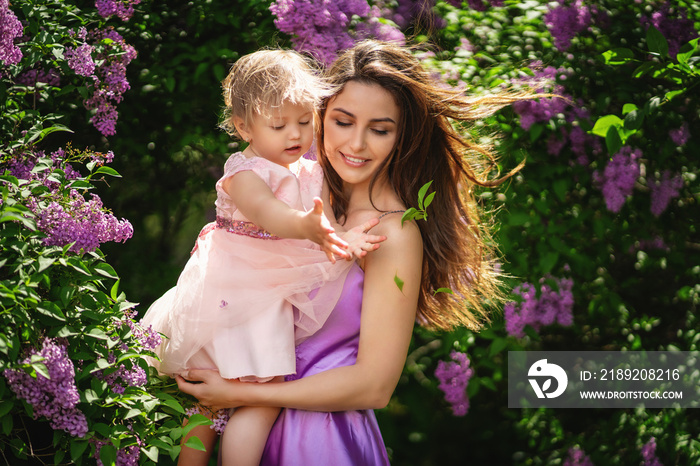 Happy family. Young beautiful mother and her daughter having fun on the park. Wind in the hair