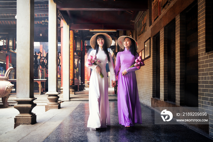 Vietnam woman wearing Ao Dai culture traditional at old temple at Ho Chi Minh in Vietnam,vintage sty