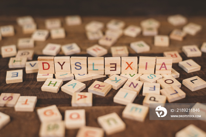 木桌上中央有DYSLEXIA单词的木制字母块的高角度视图。Concep