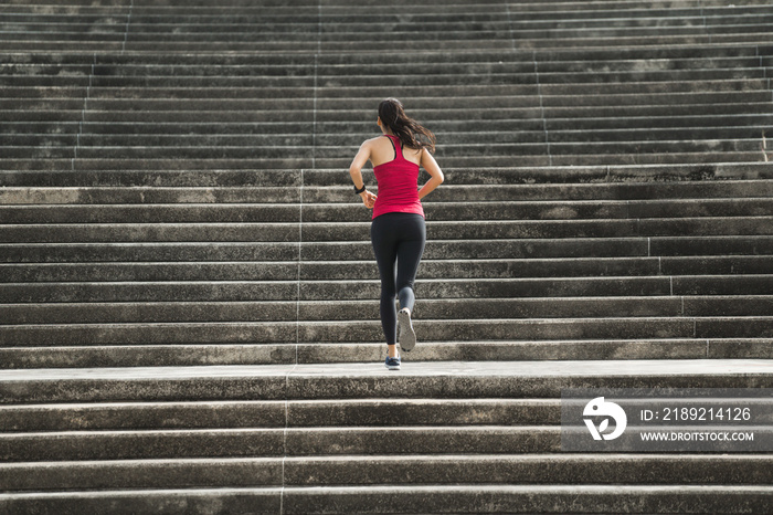 Fitness woman she is running up the stairs.