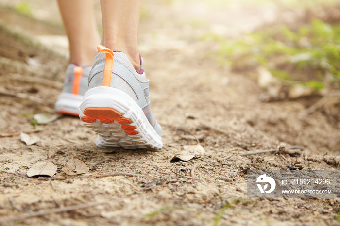 运动、健身和健康的生活方式理念。女性跑步者走路或慢跑的定格特写