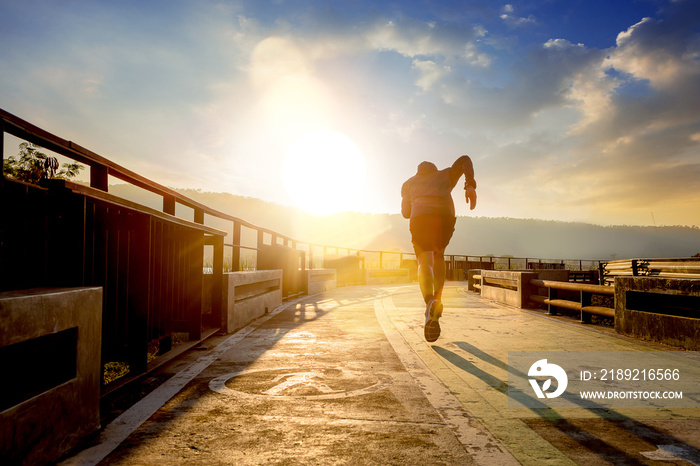 Silhouette of man running sprinting on walk way. Fit male fitness runner during outdoor workout with