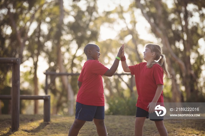 Happy kids giving high five during obstacle course