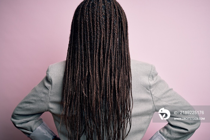 Young african american business woman standing over pink isolated background standing backwards look