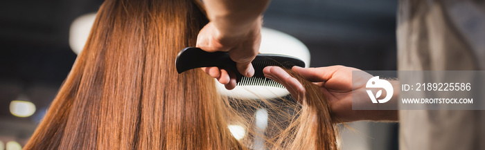 hairstylist combing hair of woman on blurred foreground, banner