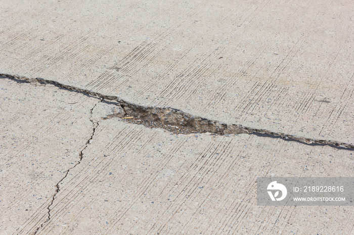 道路裂缝，混凝土车道表面有裂缝和草地