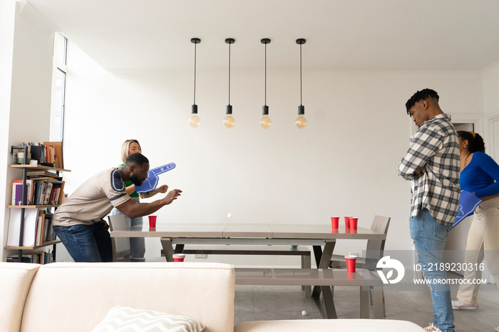 Friends�playing beer pong at home party