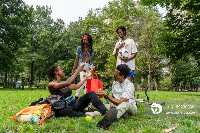 Group of young friends relaxing on lawn in park