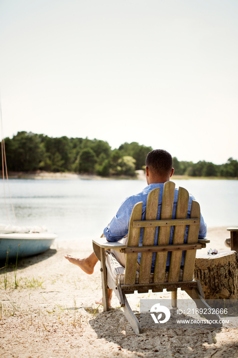 Man sitting in chair looking at river