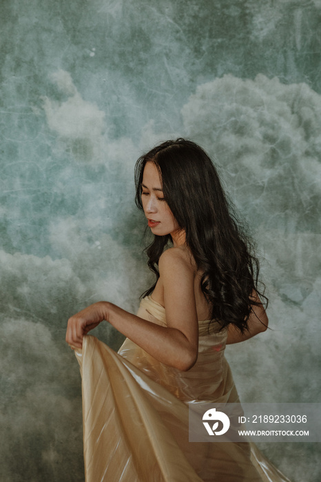 portrait of a Chinese woman looking down holding fabric