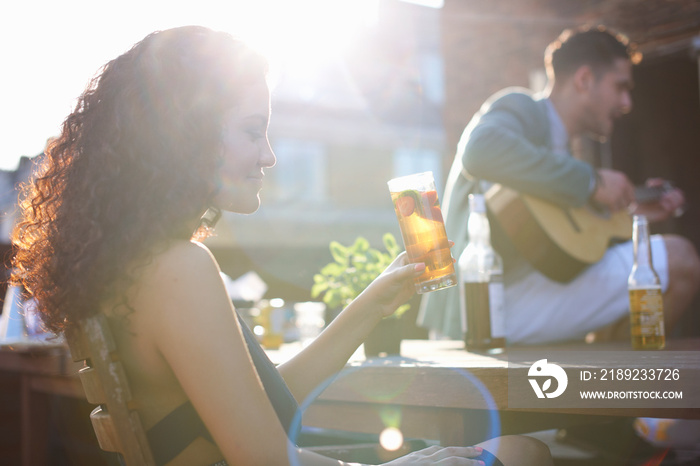 Woman at early evening party, guitarist in background