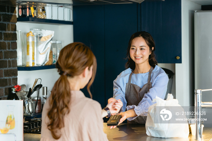 カフェ（飲食店）でスマートウォッチ決済をする女性