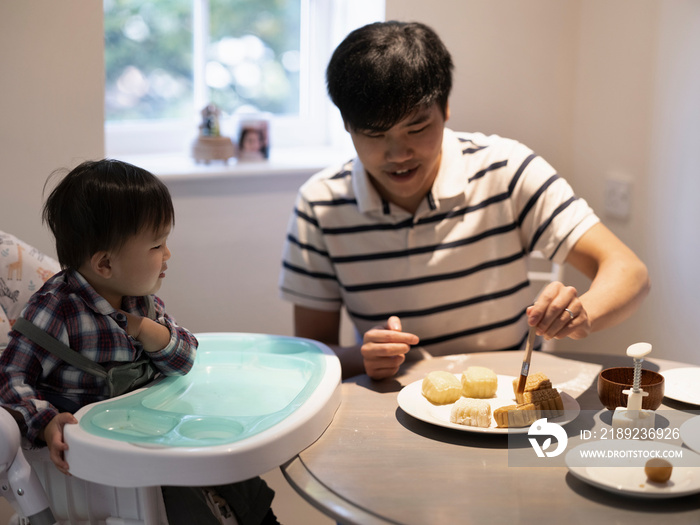 父亲带着小儿子在家做月饼