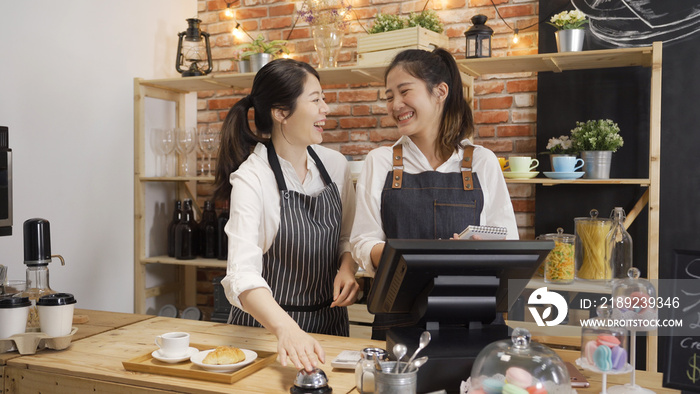 年轻的女咖啡师为顾客点餐做好准备，并在木头上按下餐厅服务铃声